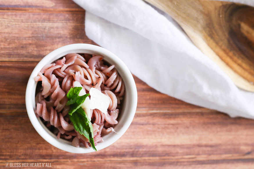 This gluten free red wine pasta + garlic basil goat cheese sauce is the perfect quick and fancy date night recipe that's ready in under 20 minutes! The pasta is cooked and stained in red wine and then tossed in a creamy garlic basil goat cheese sauce.