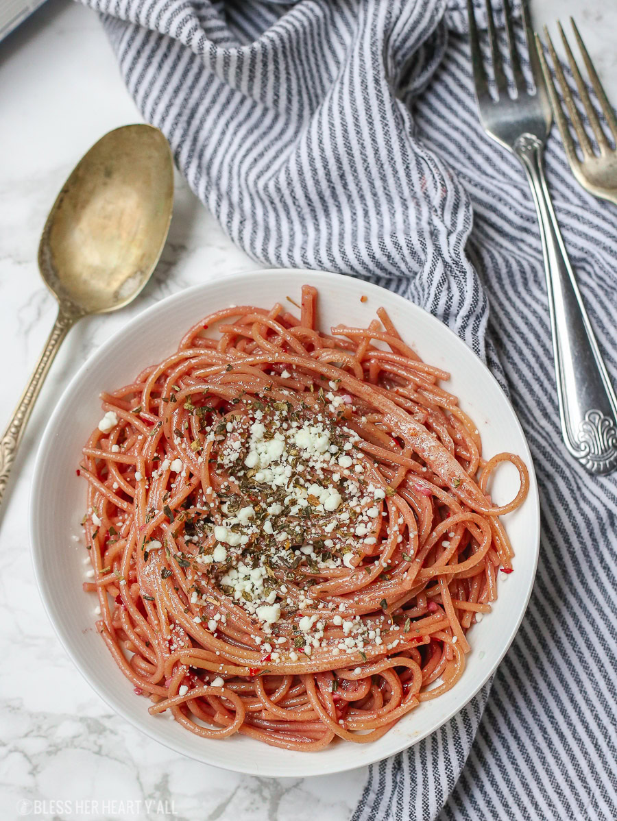 This gluten free red wine pasta + garlic basil goat cheese sauce is the perfect quick and fancy date night recipe that's ready in under 20 minutes! The gluten free pasta is cooked and stained in red wine and then tossed in a creamy garlic basil goat cheese sauce.