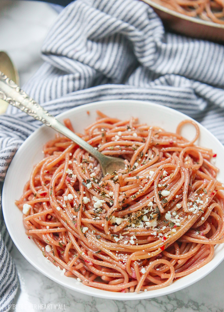 This gluten free red wine pasta + garlic basil goat cheese sauce is the perfect quick and fancy date night recipe that's ready in under 20 minutes! The gluten free pasta is cooked and stained in red wine and then tossed in a creamy garlic basil goat cheese sauce.