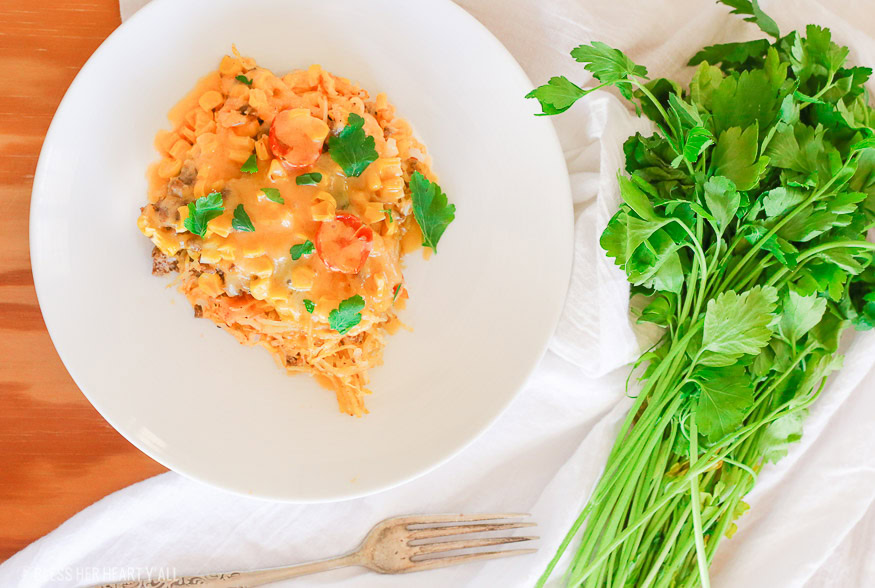 Spaghetti squash taco bake roasts fluffy spaghetti squash and melts it into seasoned ground meat, tomatoes, onion, corn, beans, and tops it off with melty cheese and fresh cilantro for the perfect healthy taco-inspired casserole!