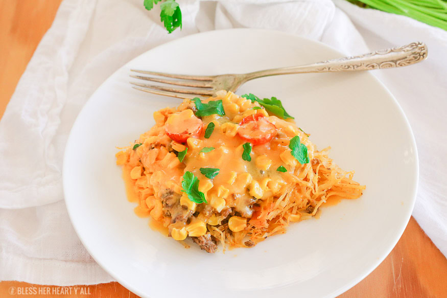 Spaghetti squash taco bake roasts fluffy spaghetti squash and melts it into seasoned ground meat, tomatoes, onion, corn, beans, and tops it off with melty cheese and fresh cilantro for the perfect healthy taco-inspired casserole!