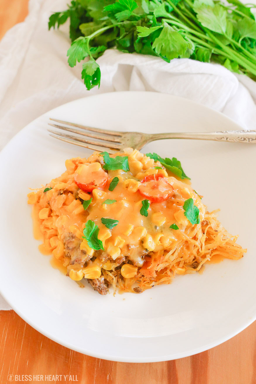 Spaghetti squash taco bake roasts fluffy spaghetti squash and melts it into seasoned ground meat, tomatoes, onion, corn, beans, and tops it off with melty cheese and fresh cilantro for the perfect healthy taco-inspired casserole!