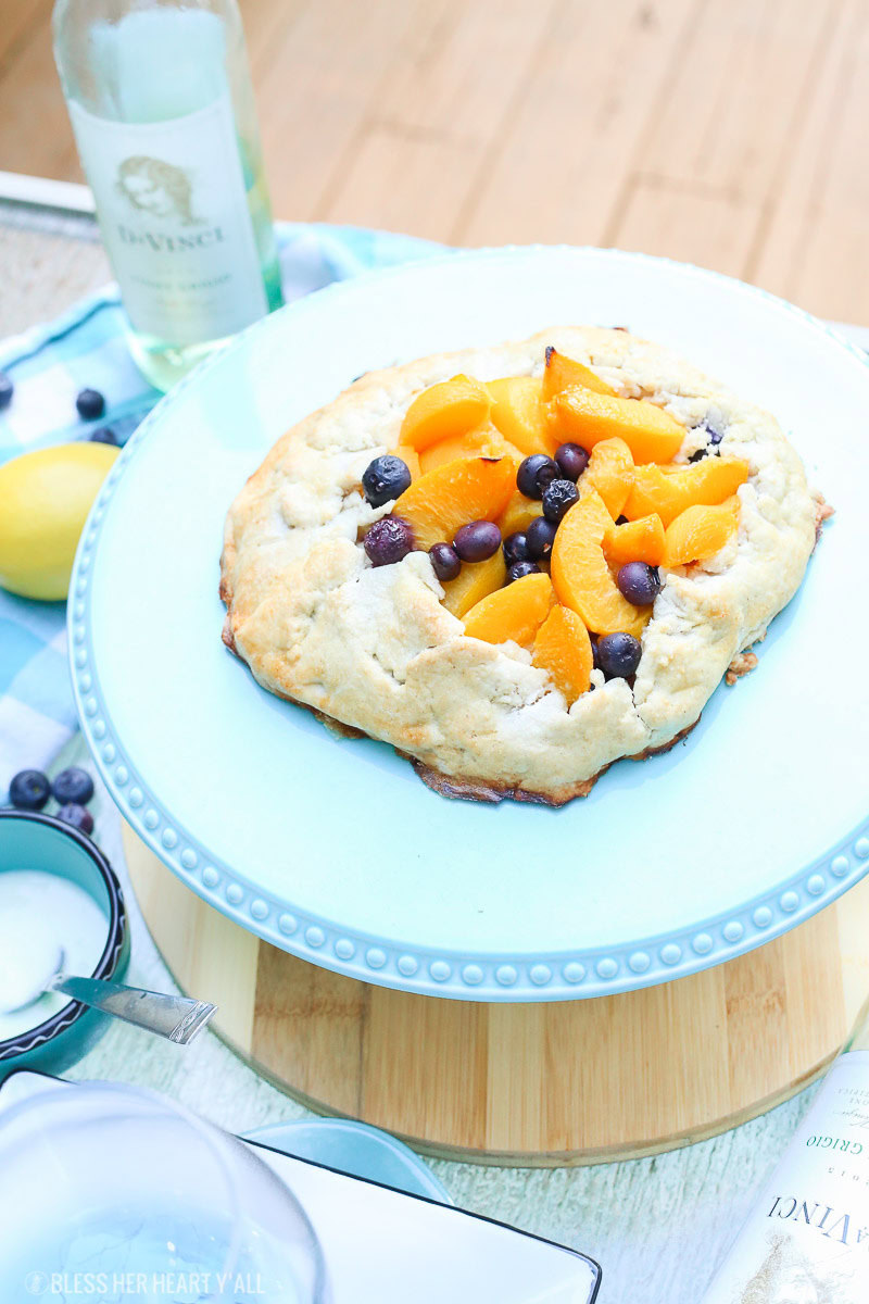 This peach blueberry galette combines peach slices and fresh blueberries in a sweet juicy sauce and then spreads it inside a doughy sugar-lined crust and bakes it all to golden perfection. This gluten free tart is drizzled in a light lemon glaze and is the perfect summer snack to enjoy outside on the back deck with a chilled bottle of white wine!