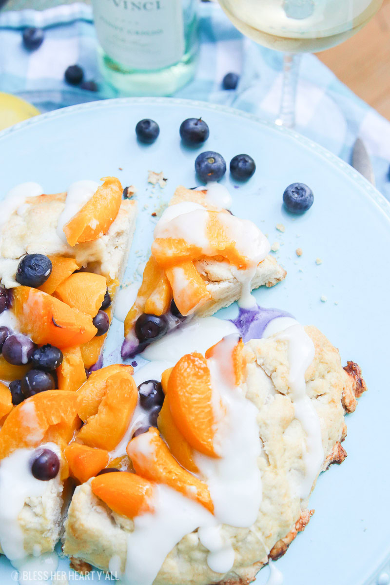 This peach blueberry galette combines peach slices and fresh blueberries in a sweet juicy sauce and then spreads it inside a doughy sugar-lined crust and bakes it all to golden perfection. This gluten free tart is drizzled in a light lemon glaze and is the perfect summer snack to enjoy outside on the back deck with a chilled bottle of white wine!