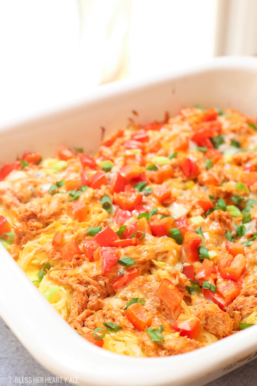 Skinny buffalo chicken spaghetti squash bake combines creamy flavor-packed buffalo chicken with fresh veggies and blue cheese crumbles all on a bed of spaghetti squash!