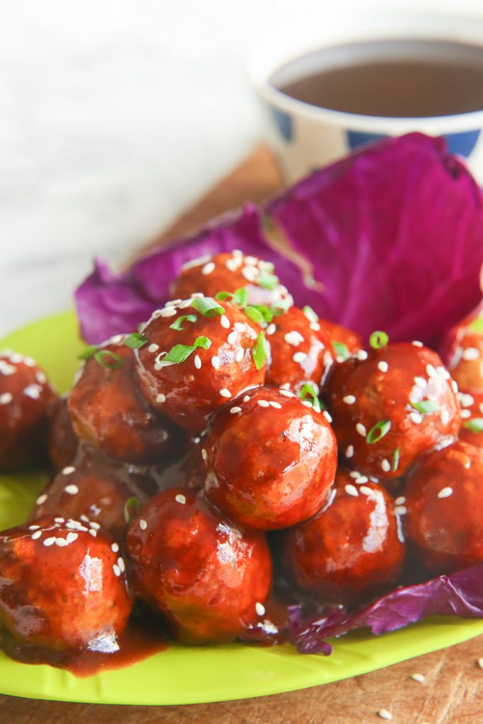 asian chicken meatballs on bright green platter