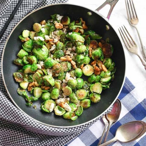 overhead view of brussel sprouts and walnuts in skillet pan