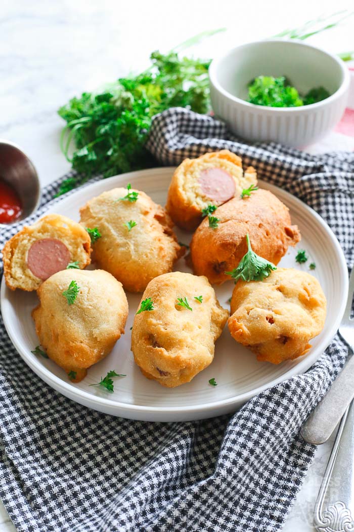 mini gluten free corn dogs on a white plate with ketchup