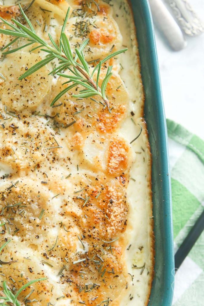 overhead closeup shot of scalloped potatoes in aqua baking dish