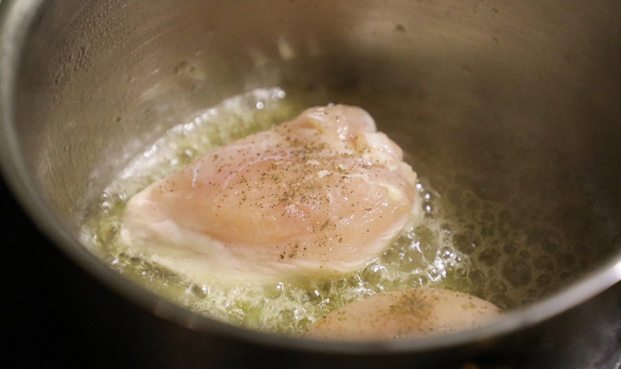 Chicken breast cooking in a skillet