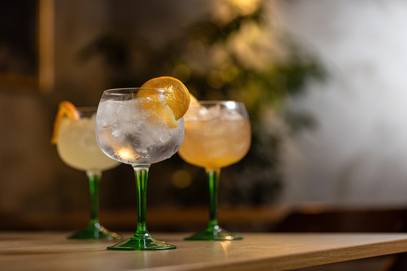 Alcoholic drink gin tonic cocktail with orange on restaurant table