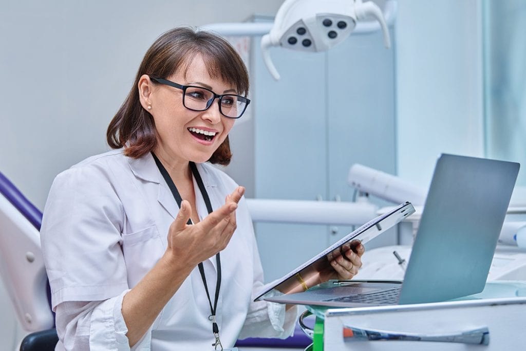 A happy dentist reading a chart