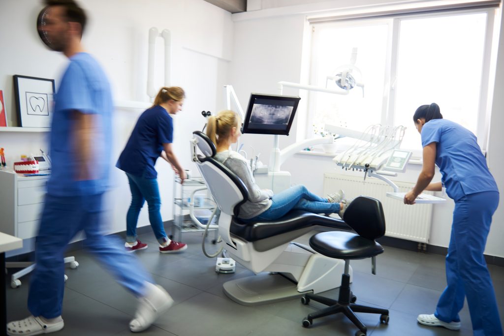 Dental team moving/working around patients.
