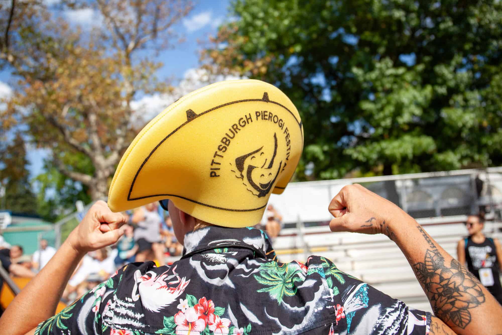 A person wearing a Pittsburgh Pierogi Festival foam hat.