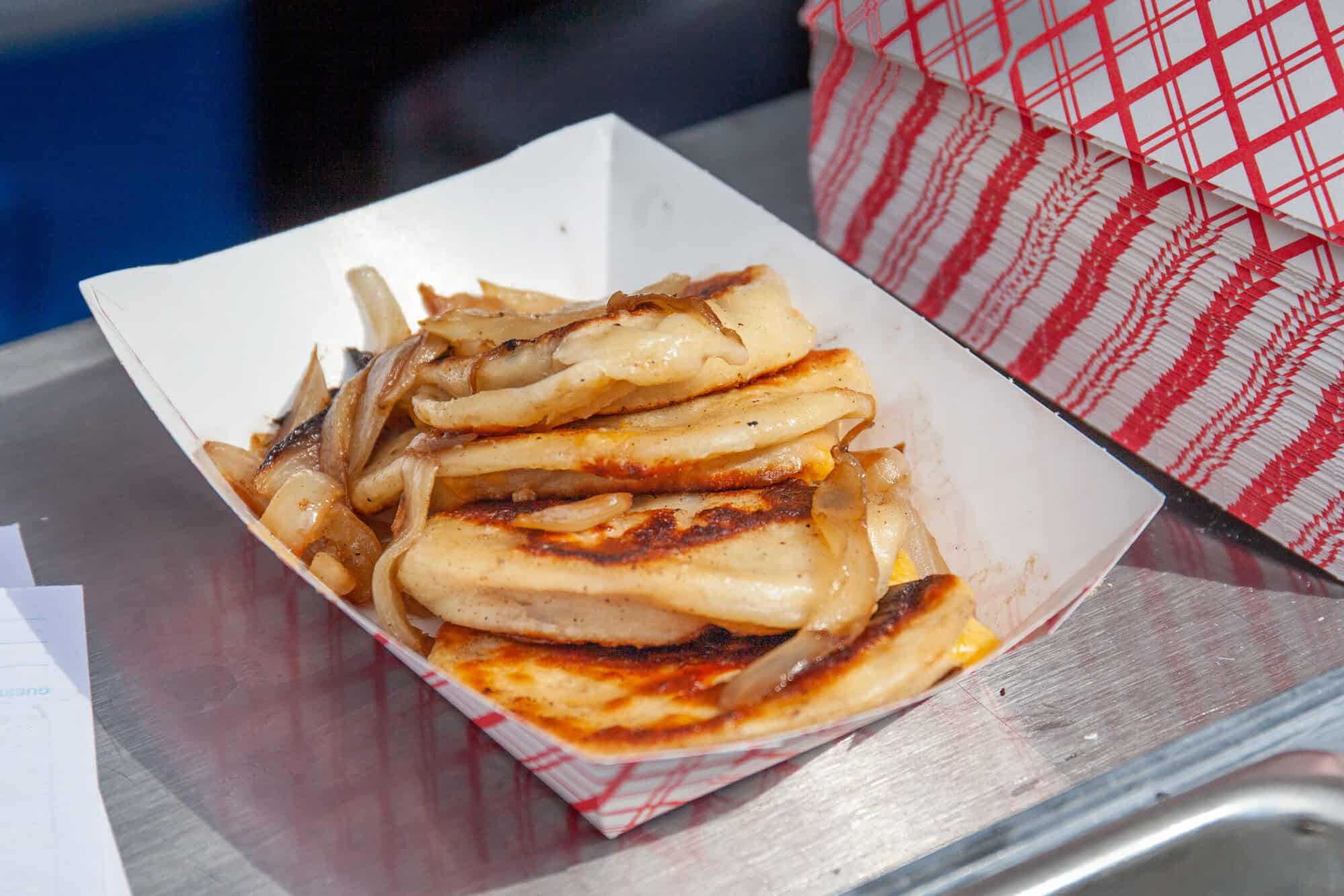 A photo of pierogies with onions.