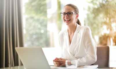 laughing businesswoman working in office with laptop