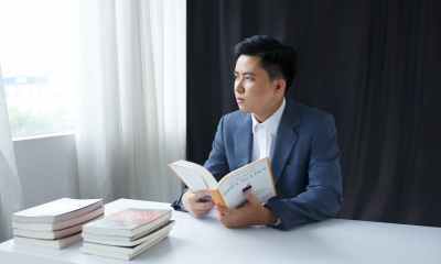photo of a pensive young man in a suit holding a book