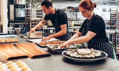 man and woman wearing black and white striped aprons cooking