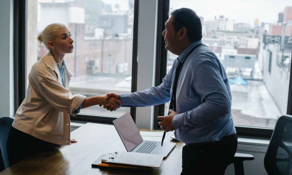 young woman shaking hands with boss after business presentation