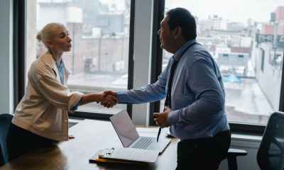 young woman shaking hands with boss after business presentation