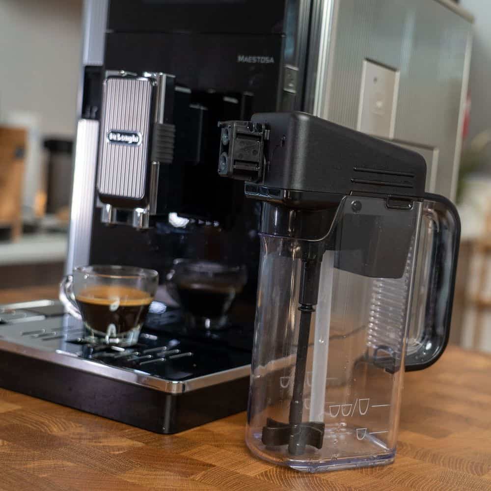 Delonghi Maestosa Kaffeevollautomat mit Mixkaraffe im Vordergrund