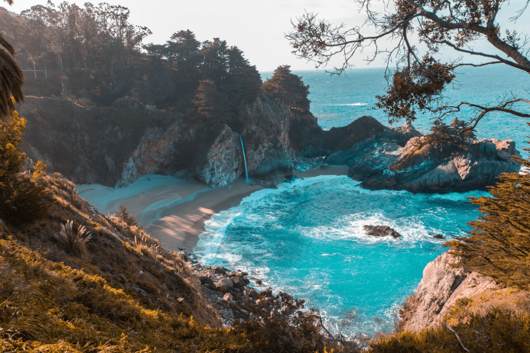 body_of_water_near_trees_and_mountain_cliff_during_daytime