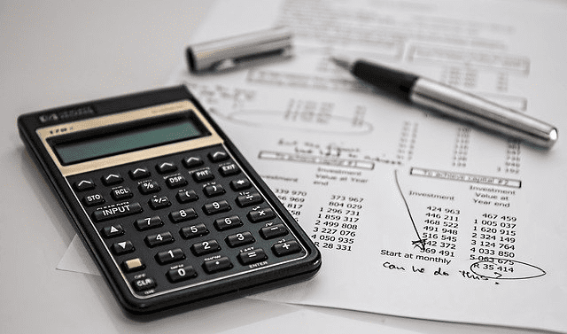 calculator on paper with silver pen