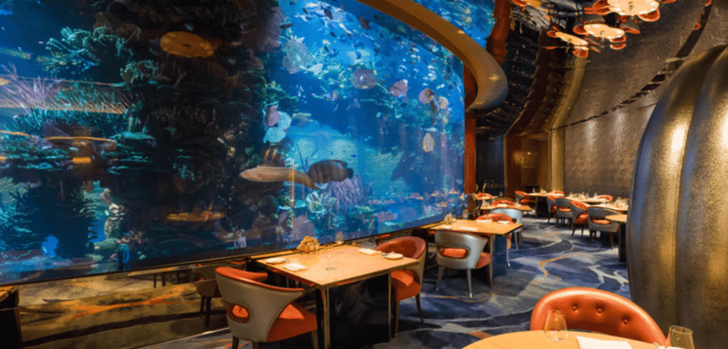 restaurant with tables next to aquarium 
