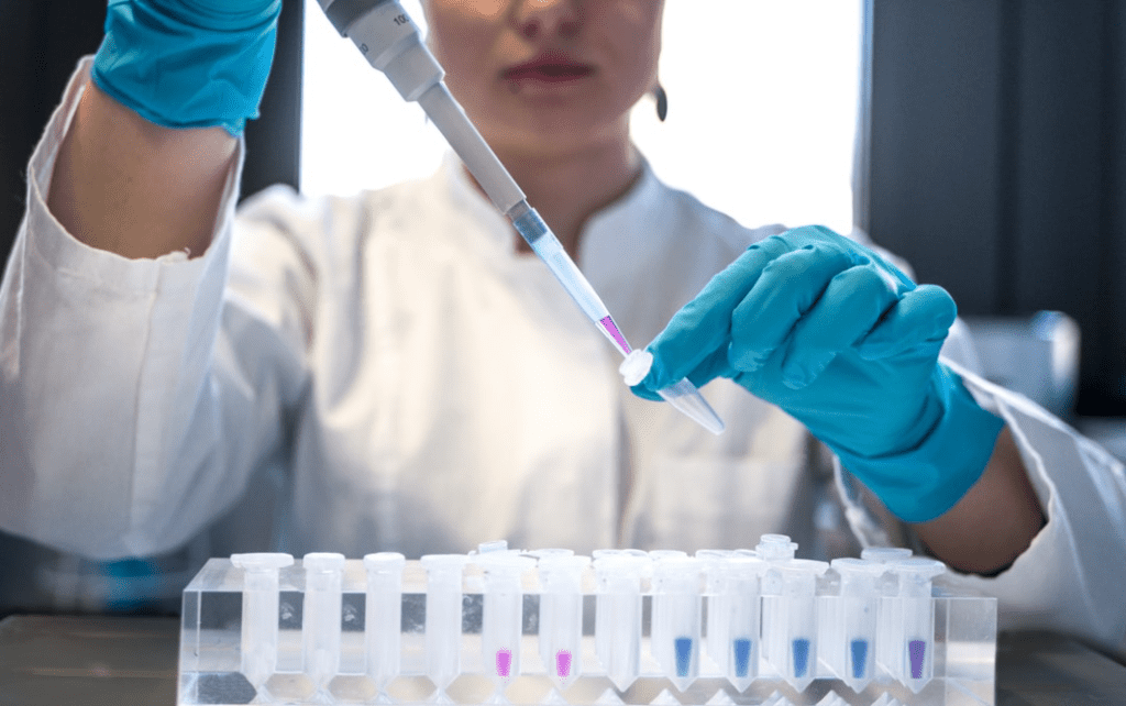 scientist putting liquid into test tubes