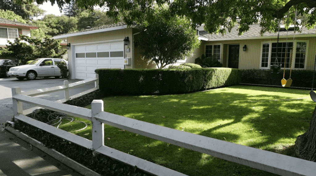 garden with picket fence next to house and garage