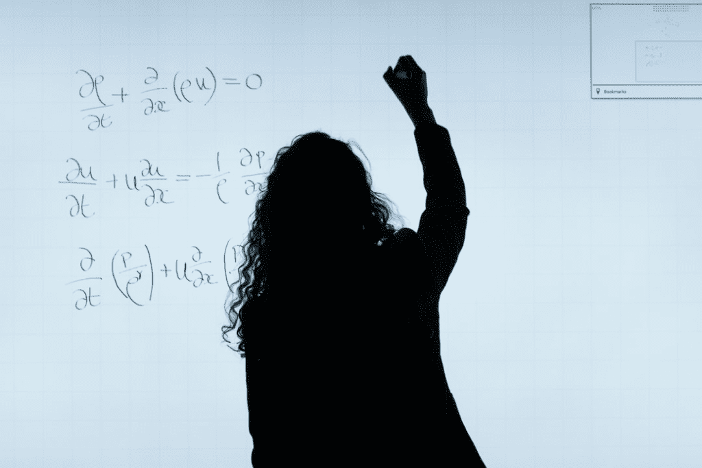 person writing formula on white board