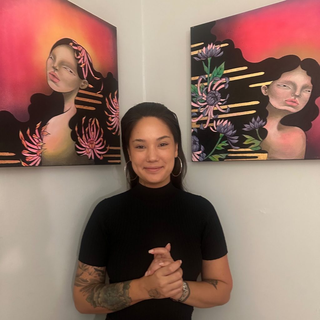 Photo of artist with her two paintings.