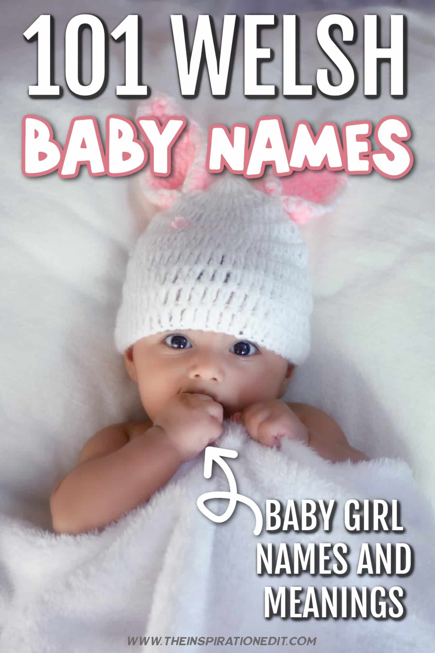 Baby in a white and pink hat, covered in white fuzzy blanket.