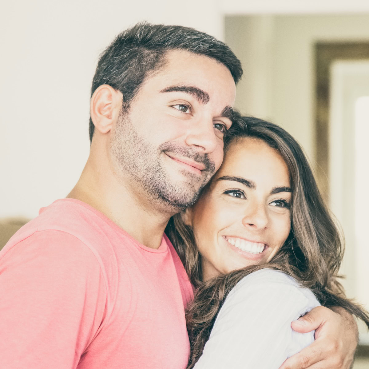 husband and wife hugging and smiling.