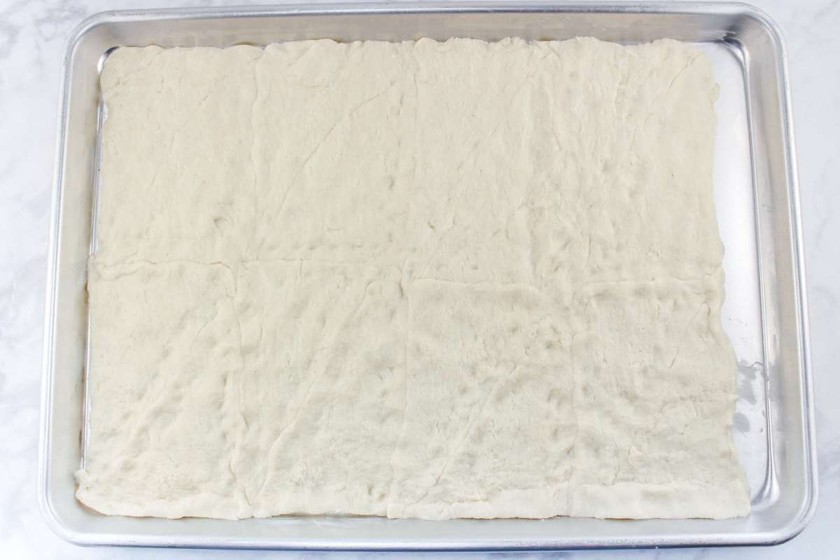 Crescent rolls dough in a baking sheet.