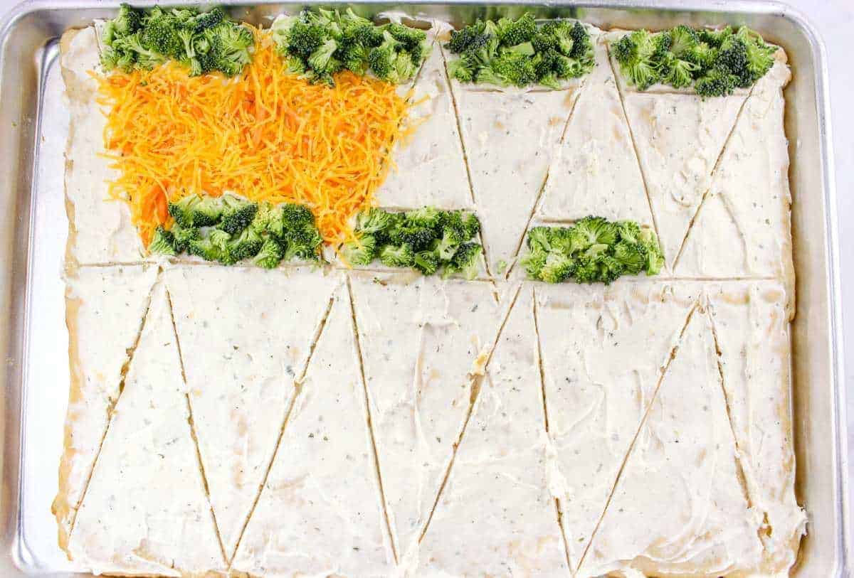 Sprinkling crushed carrots over dough for carrot bars.