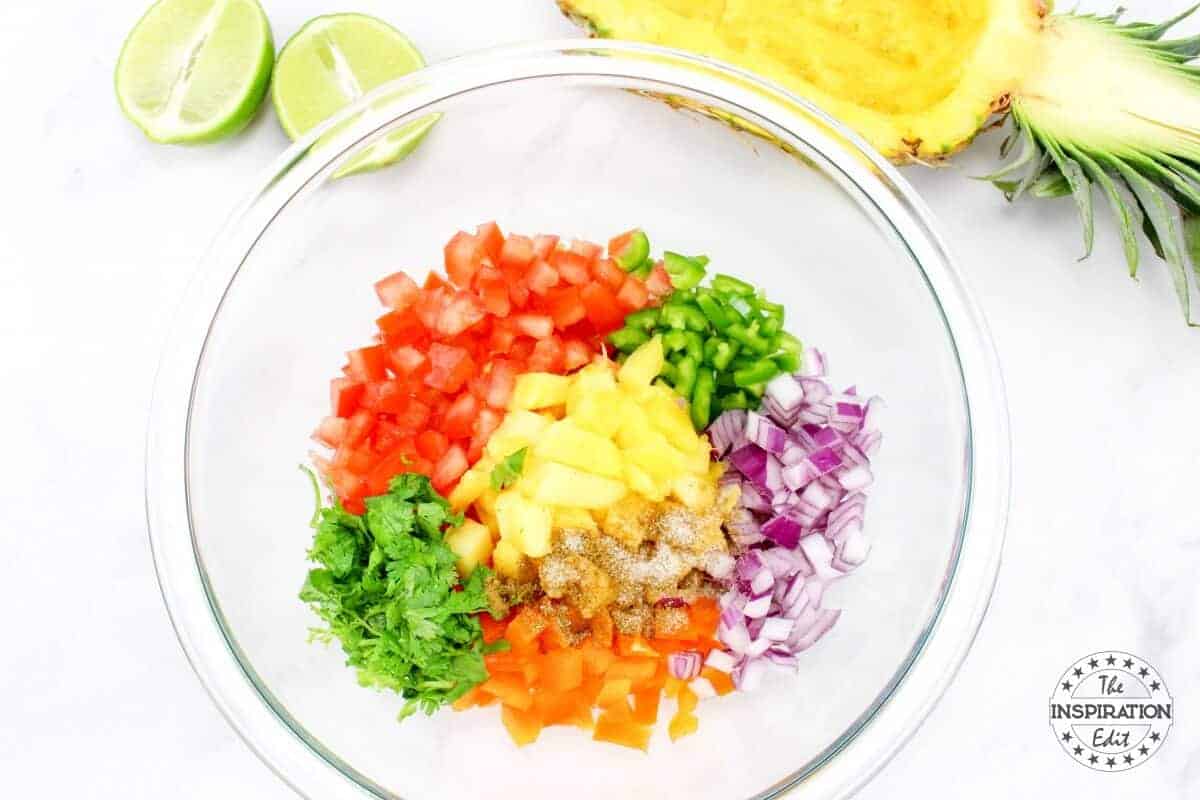 Chopped vegetables and pineapple in a large bowl.