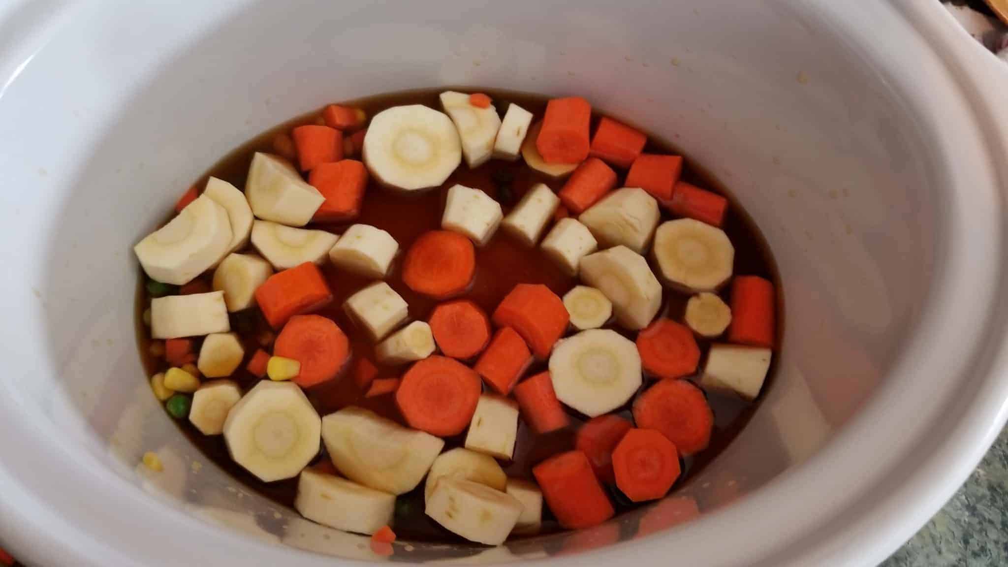 Vegetables and sauces in a slow cooker.