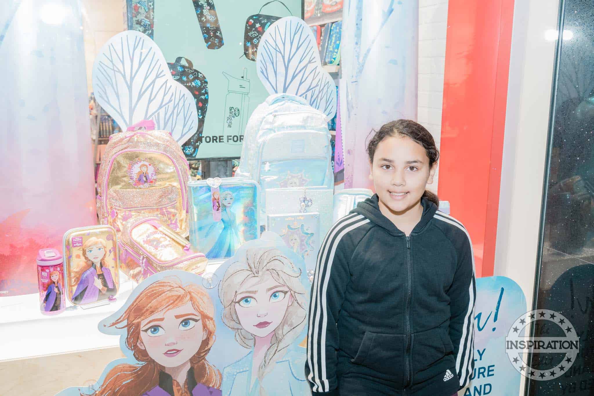 a girl smiling in frozen two smiggle background.