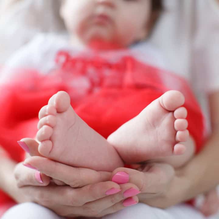 Biblical Baby Names For Girls | A mom holding her baby daughter in her lap.