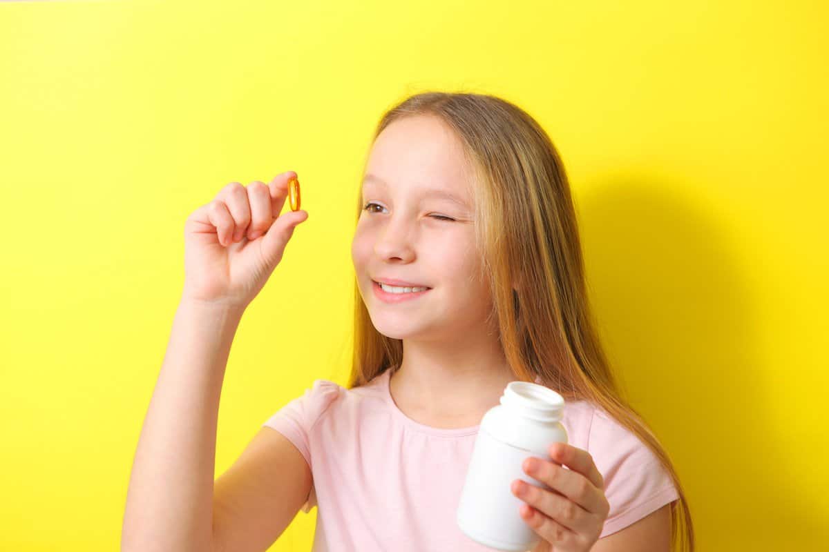 Children Should Have Multivitamins | A teenage girl taking multivitamins.