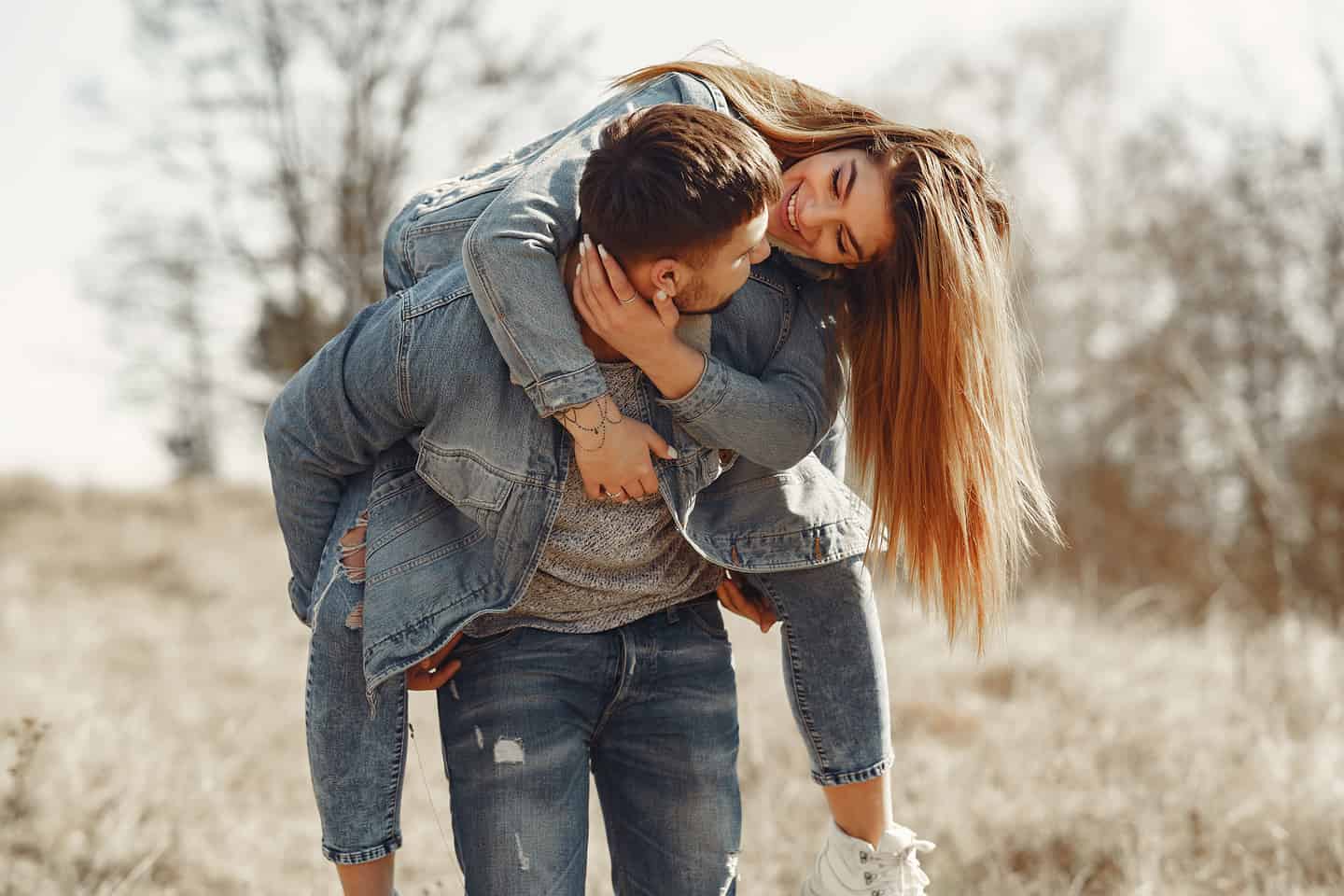 Cute Couple in Jeans Clothes in a Spring Field.