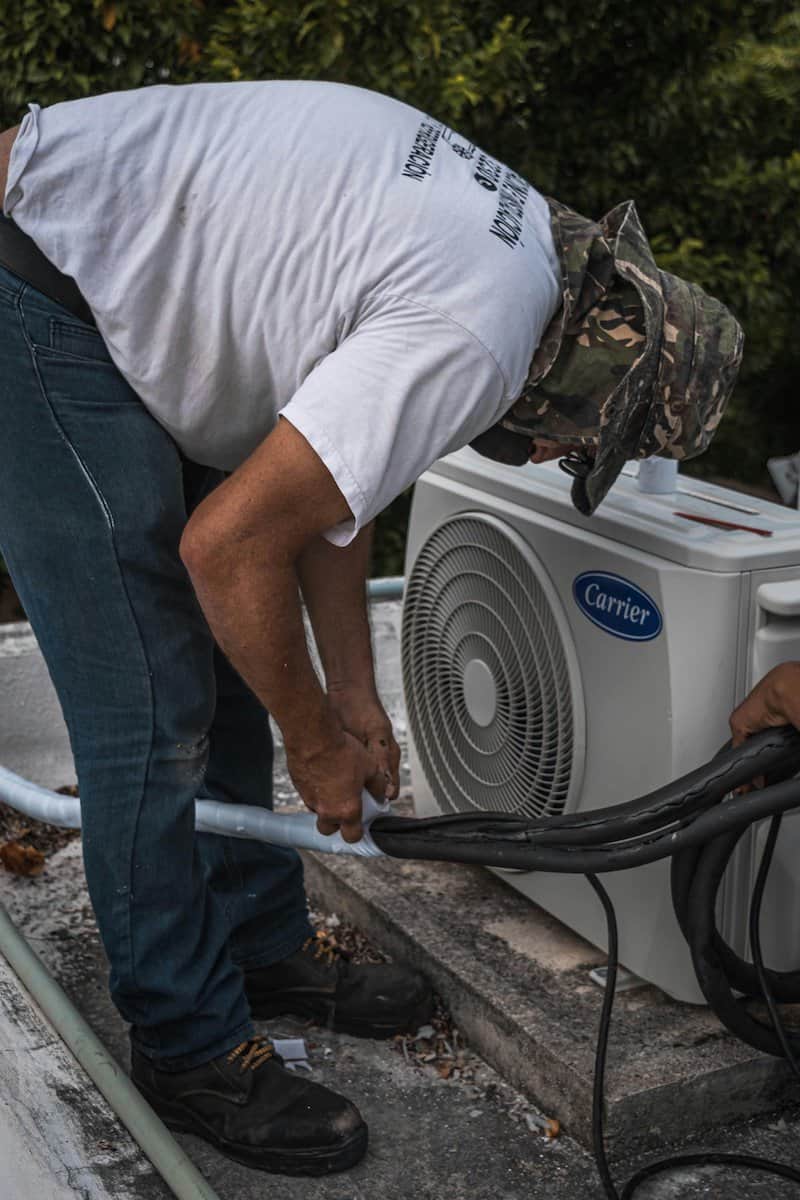 The Role of HVAC Systems | Man servicing HVAC System.
