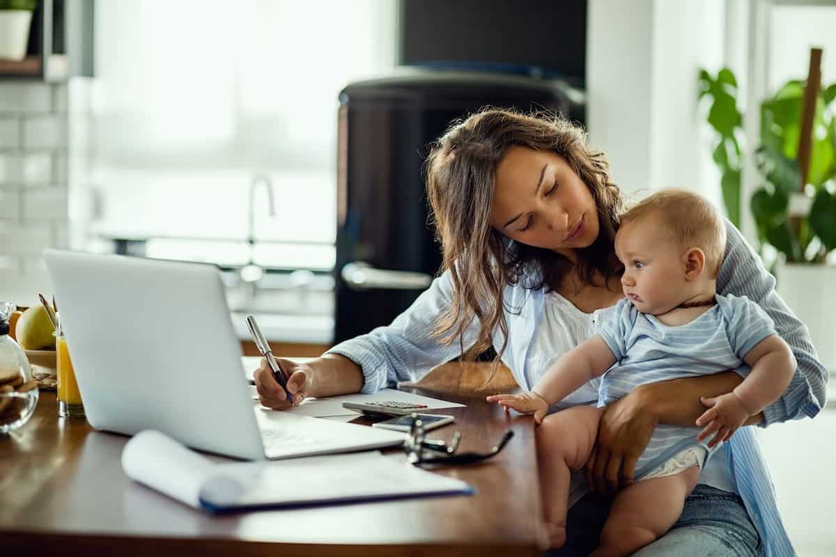A Working Mom from home with a child on her lap.
