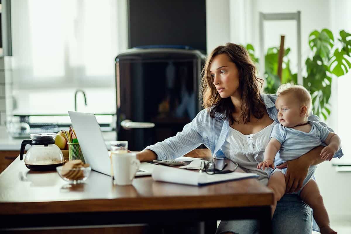 A Working Mom from home with a child on her lap.