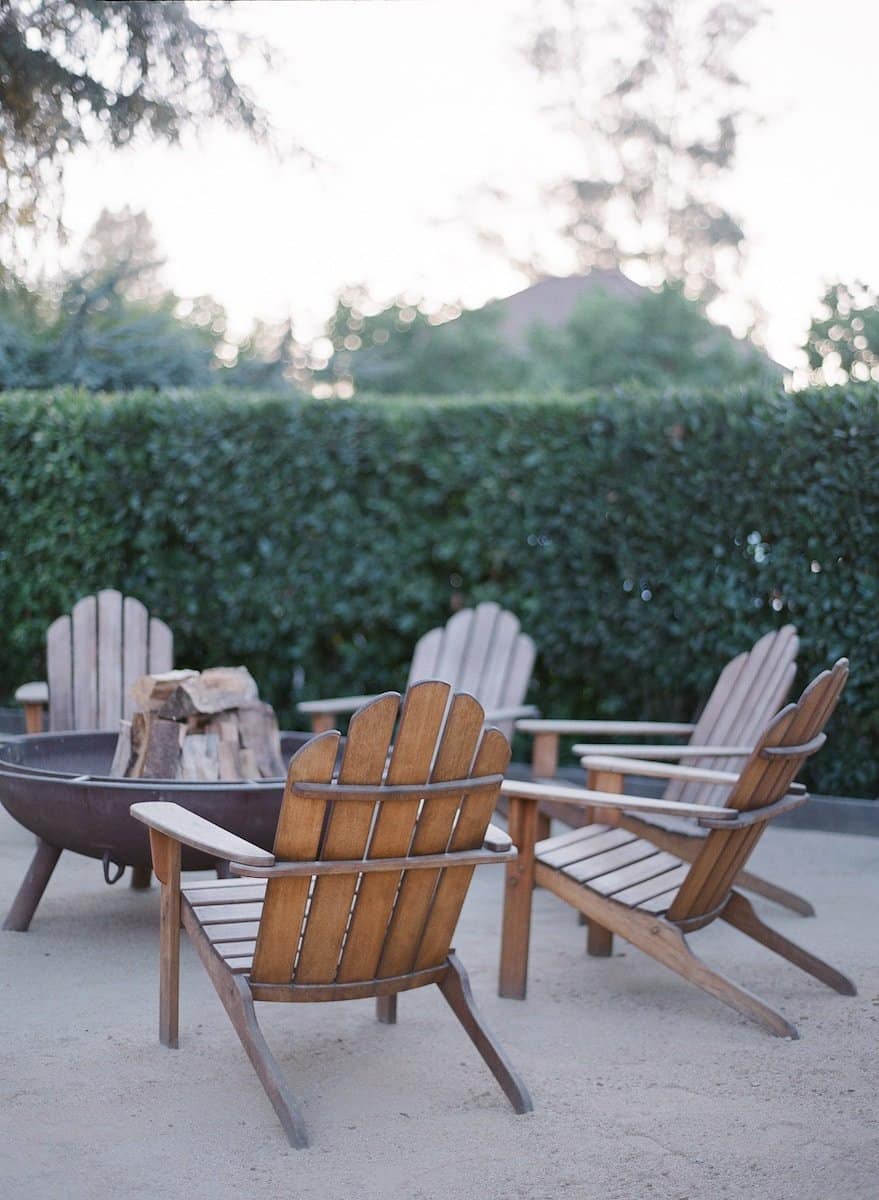 Bring Your Backyard to Life | Empty chairs around an open log fire.
