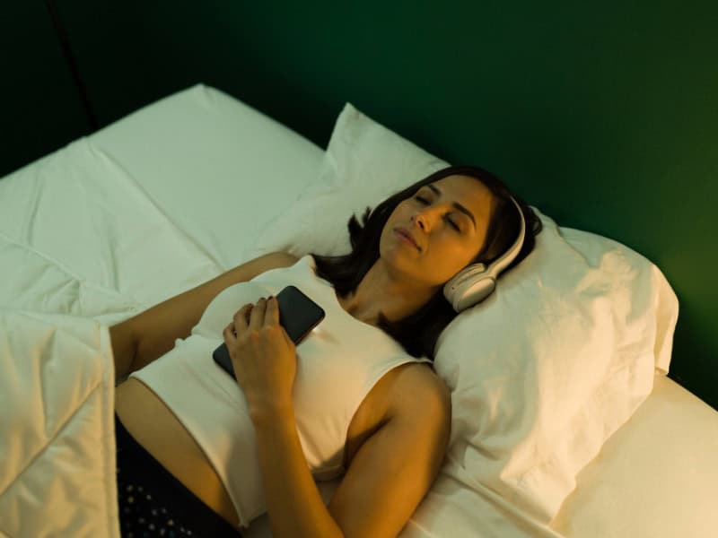Sleep Is The Key To A Healthier Life | A Woman listening to calming music to Sleep properly.