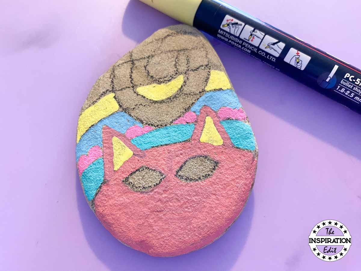 painting the base layers of a cat on a rock. 