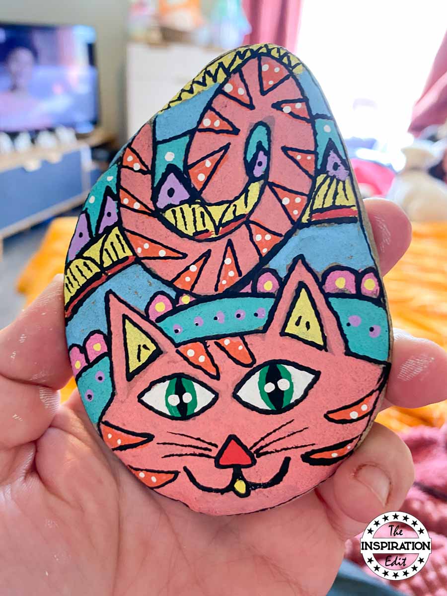 Cat painted rock on a stone. 