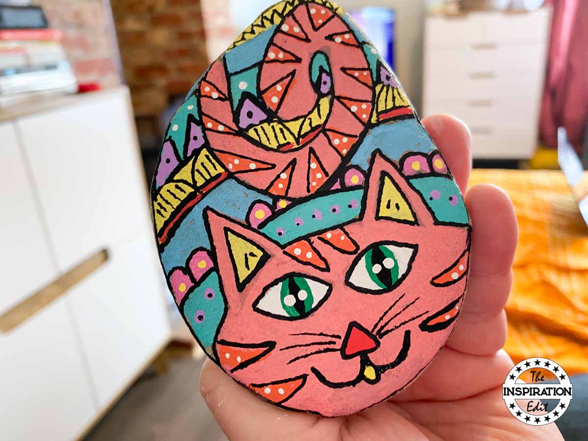 Cat painted rock on a stone. 